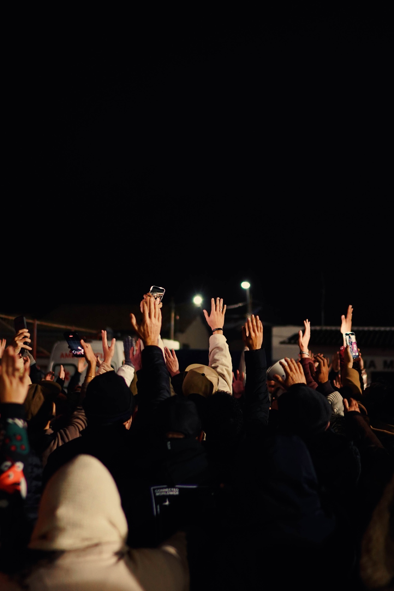 Mãos levantadas em louvor à noite